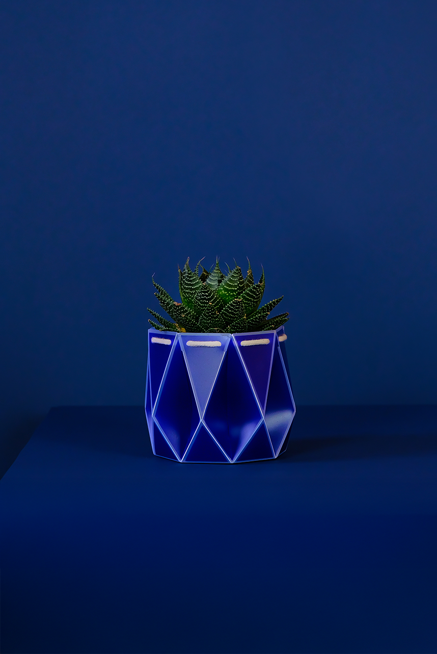 Self watering POTR Pot displaying a stylish blue planter with a succulent on a blue background.