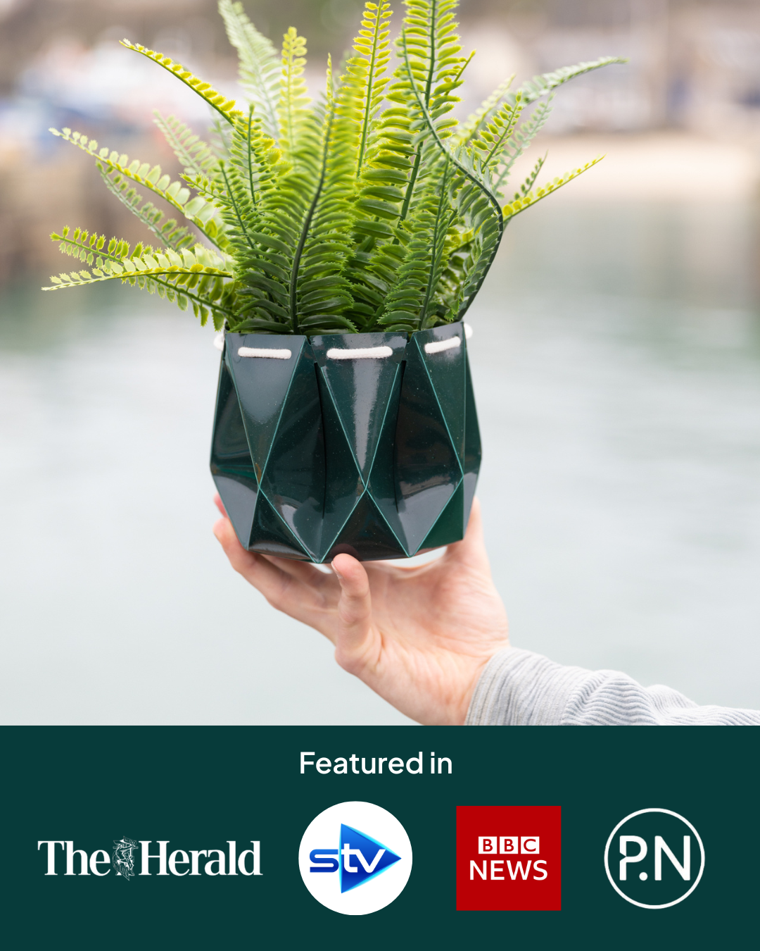 Self watering Ocean Plant Pot held by a person, featuring green foliage and a unique origami design.